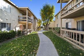 Palmdale apartment for rent - A pathway leads between two buildings with balconies.
