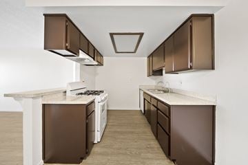 Palmdale apartment for rent - A kitchen with brown cabinets and a white counter.