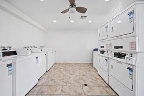 Rialto apartment for rent - A room with a white ceiling and floor, containing a row of washing machines.