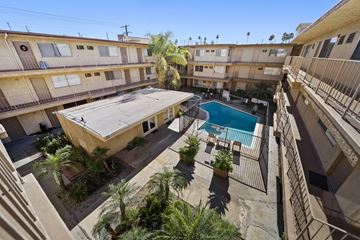 Van Nuys apartment for rent - A pool in the middle of a courtyard surrounded by buildings.