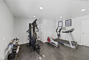 Van Nuys apartment for rent - A home gym with a treadmill, elliptical trainer, and a weight machine.