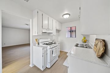 Lancaster apartment for rent - A white kitchen with a stove, sink, and cabinets.