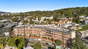 Los Angeles apartment for rent - A large apartment complex is surrounded by trees and other buildings.