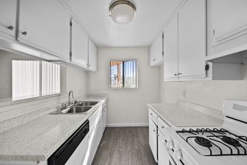Los Angeles apartment for rent - A kitchen with white cabinets and a white stove top oven.