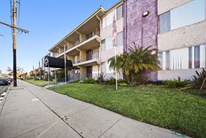 Van Nuys apartment for rent - A purple building with a flag on the balcony.