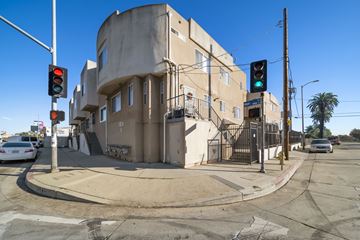 Los Angeles apartment for rent - A street corner with a traffic light and a building.