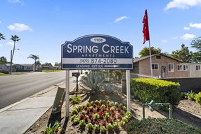 Rialto apartment for rent - Spring Creek Apartments sign with a red flag on top.