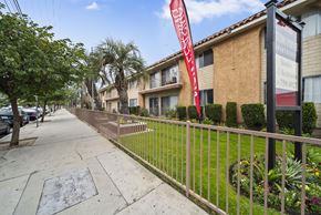 North Hollywood apartment for rent - A red banner with white text hangs on a black pole in front of a building.
