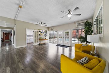 North Hollywood apartment for rent - A living room with a yellow couch and a ceiling fan.
