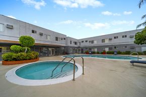 North Hollywood apartment for rent - A swimming pool is surrounded by a concrete building.