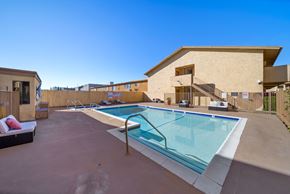 Van Nuys apartment for rent - A swimming pool in a backyard with a building in the background.