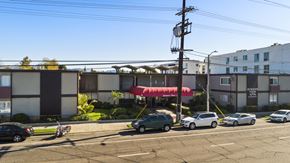 Panorama City apartment for rent - A parking lot with cars and a building in the background.