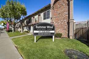 Palmdale apartment for rent - A sign for Summer Wind Apartments is in front of a brick building.