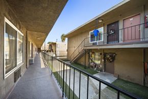 North Hills apartment for rent - A long concrete balcony with a black railing.