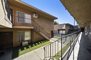 North Hills apartment for rent - A sunny day at a residential area with apartment buildings and a metal fence.