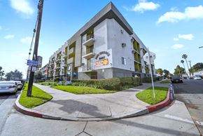 Panorama City apartment for rent - A white building with a red stripe on the side of the road.