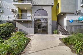 Panorama City apartment for rent - A building with a yellow accent and a black gate.