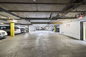 Panorama City apartment for rent - A parking garage with a concrete floor and yellow poles.