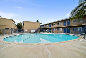 Long Beach apartment for rent - A large outdoor swimming pool surrounded by a fence.
