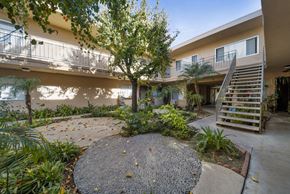 Reseda apartment for rent - A courtyard with a tree and a gravel circle.