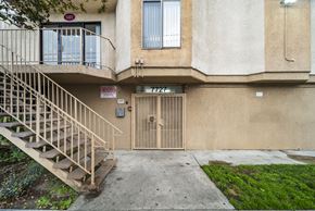 North Hollywood apartment for rent - A building with a staircase leading to a door with a sign on it.