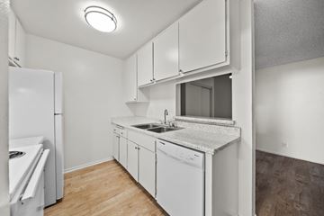 North Hollywood apartment for rent - A small, white kitchen with a sink and a refrigerator.
