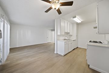 Palmdale apartment for rent - A kitchen with white cabinets and a wooden floor.