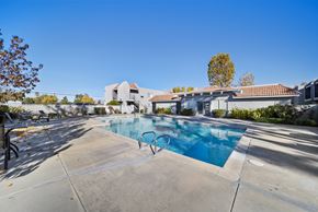 Palmdale apartment for rent - A swimming pool in a residential area with a house in the background.