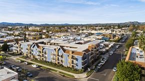 Canoga Park apartment for rent - A view of a residential area with apartment buildings and cars parked on the street.