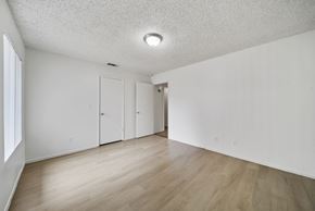 Avenal apartment for rent - A room with white walls and wooden flooring with a window on the left side.
