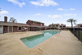 Avenal apartment for rent - A swimming pool in a residential area surrounded by houses.