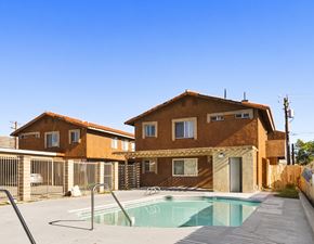Desert Hot Springs apartment for rent - A house with a brown exterior and a pool in front.