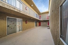 Canoga Park apartment for rent - A long hallway with a fire extinguisher on the wall.