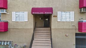 Canoga Park apartment for rent - The entrance to a building with a red awning that says Woodland Pointe.