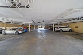 Canoga Park apartment for rent - A parking garage with a white car in the foreground.