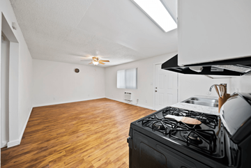 San Bernardino apartment for rent - A kitchen with a black stove top oven and wooden flooring.