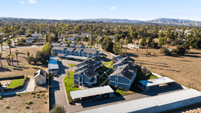 Redlands apartment for rent - A large building complex with a parking lot in front.
