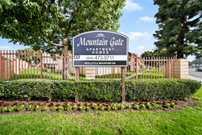 San Bernardino apartment for rent - A sign for Mountain Gate Apartment Homes is displayed in front of a fence.