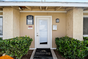 San Bernardino apartment for rent - The front door of a building with a sign that says "Mountain Gate Apartments".