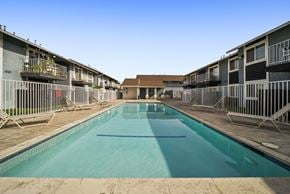 San Bernardino apartment for rent - A long rectangular pool in the middle of a courtyard surrounded by buildings.