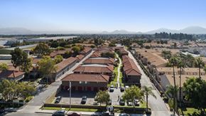 Fontana apartment for rent - A large building complex with a parking lot in front.