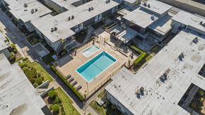 Rowland Heights apartment for rent - A swimming pool is surrounded by a concrete building.