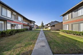 Riverside apartment for rent - A long concrete walkway separates two rows of houses.