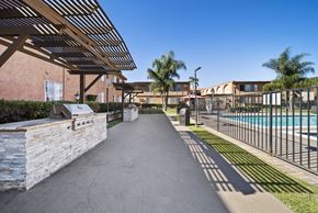 Van Nuys apartment for rent - A long concrete walkway leads to a pool area.