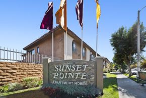 Van Nuys apartment for rent - Sunset Pointe Apartment Homes sign with flags in front.