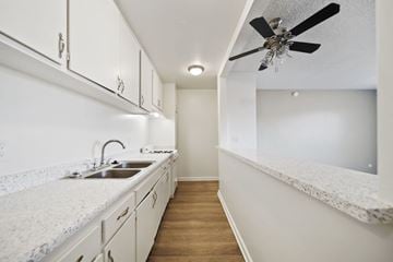 Van Nuys apartment for rent - A kitchen with white cabinets and a marble countertop.