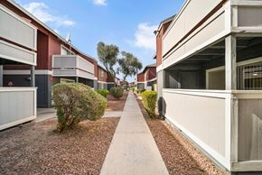 Las Vegas apartment for rent - A long concrete walkway separates two rows of identical buildings.