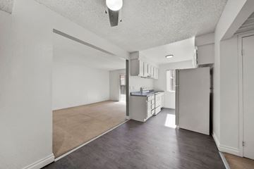 Las Vegas apartment for rent - A kitchen area with a refrigerator, sink, and cabinets.