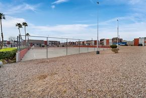 Las Vegas apartment for rent - A gravel area with a fence and palm trees in the distance.