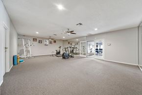 Las Vegas apartment for rent - A spacious room with a ceiling fan and exercise equipment.